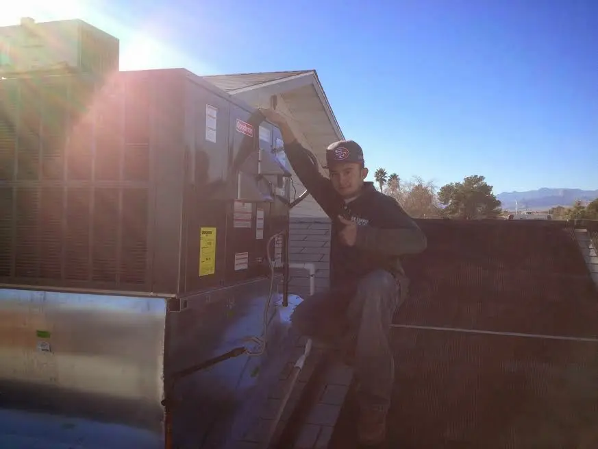 HVAC technician performing Heat Pump Repair on a rooftop unit in Collegedale